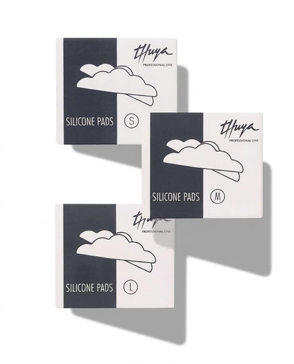 Three product boxes for Thuya Professional Line Silicone Pads in sizes S, M, and L, arranged in a staggered layout on a white background